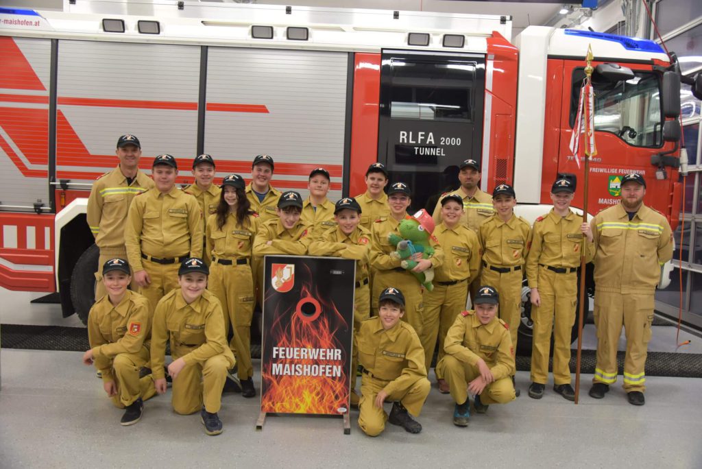 Feuerwehrjugend Maishofen in Uniform vor Löschfahrzeug, Gruppenfoto im Feuerwehrhaus, FF Maishofen