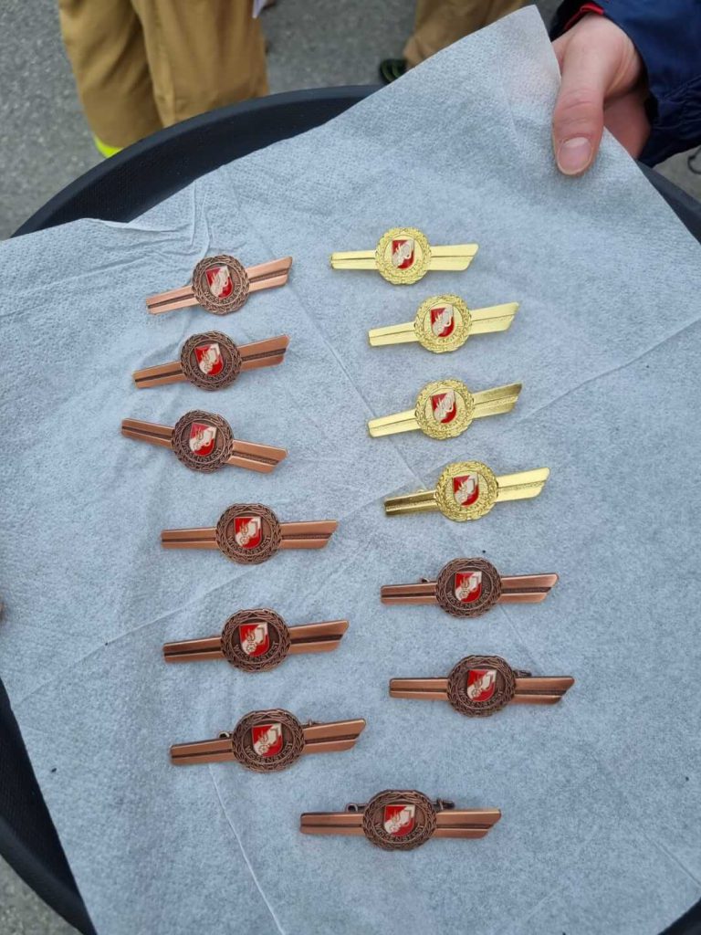 Bronze- und Goldabzeichen der Feuerwehrjugend Maishofen auf weißem Tuch vor der Verleihung