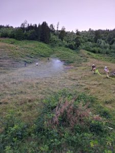 Feuerwehrleute löschen Rauchentwicklung auf bewachsenem Hügel im Freien