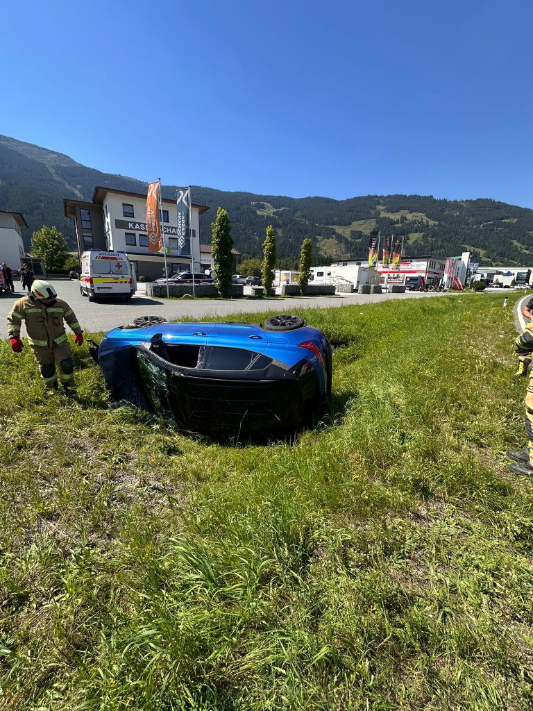 Feuerwehr und Rettung nach Verkehrsunfall mit überschlagenem Auto auf Wiese bei Maishofen