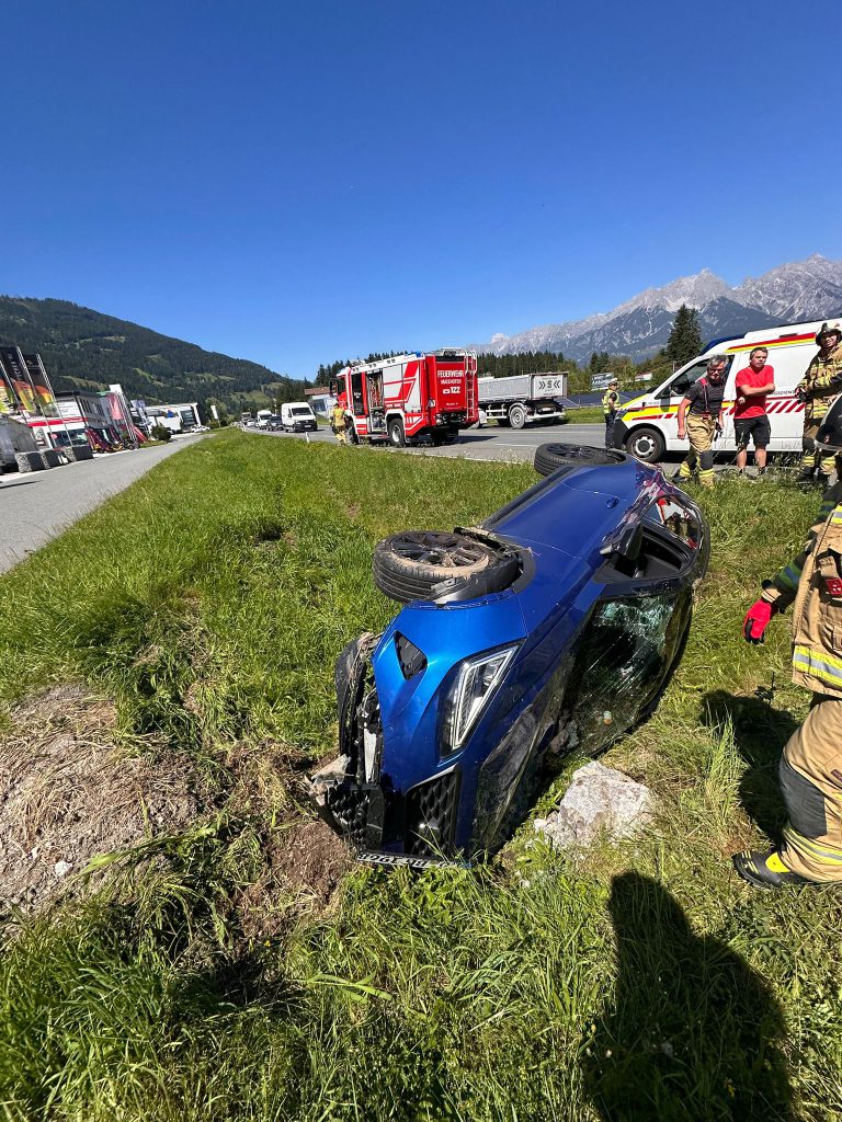Blaues Auto nach Überschlag, Feuerwehr und Rettungseinsatz auf Landstraße bei Maishofen